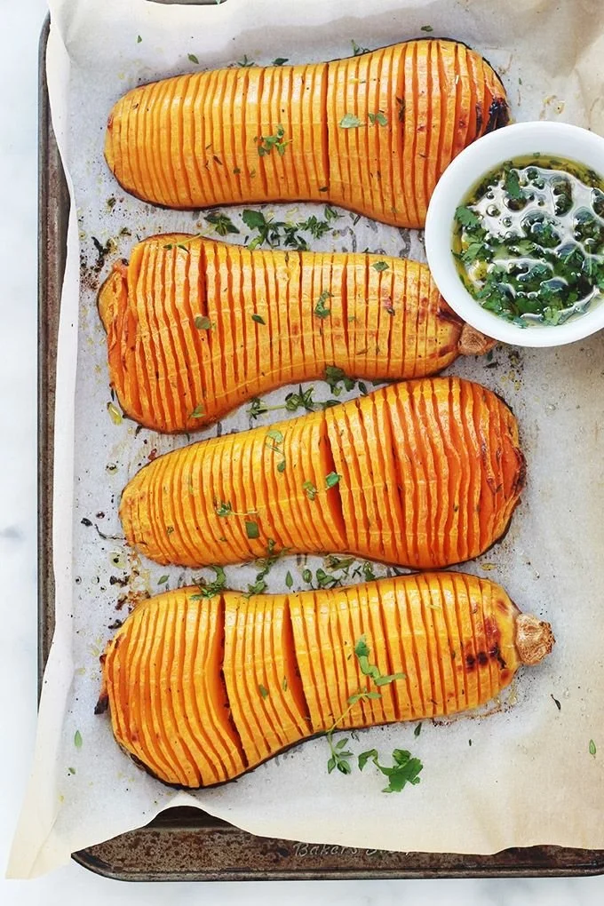 Courge butternut rôtie au four façon hasselbak, préparée avec soin.